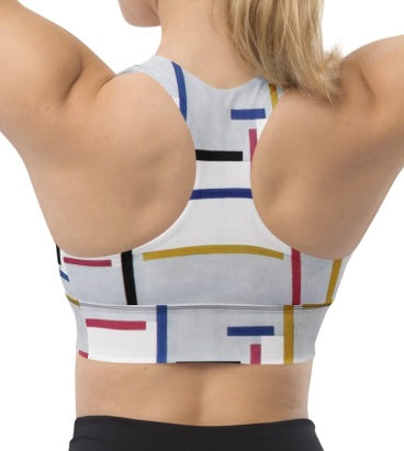 Model wearing geometric print longline sports bra with geometric racerback.