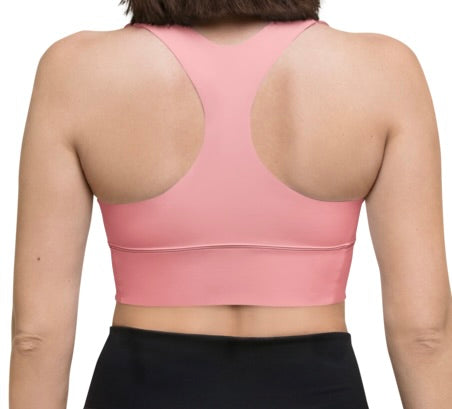 Woman wearing pink BABEDEPT logo sports bra for workouts.